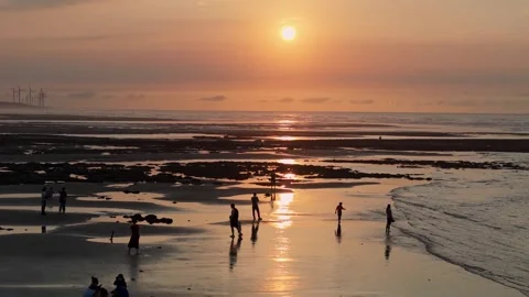Sunset Over the Beach with People and Wind Turbines 스톡 동영상 314120470