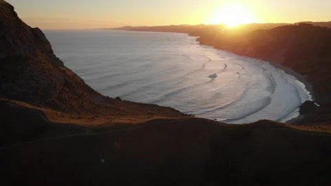 Sunset over the beach surrounded by mountains on New Zealand Coast - aerial shot Video stock 153003170