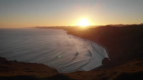 Sunset over the beach surrounded by mountains on New Zealand Coast - aerial shot Video stock 153023534