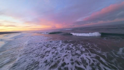 Sunset over beach with vivid pink and orange hues across sky Stock Footage 344542428