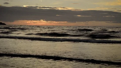 Sunset over a beach as the waves break on the shore. Olafsvik Stock Footage 83309336
