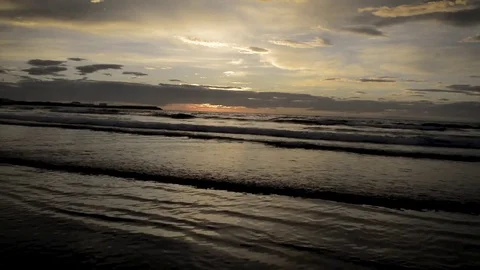 Sunset over a beach as the waves break on the shore 1 . Olafsvik Stock Footage 83309392