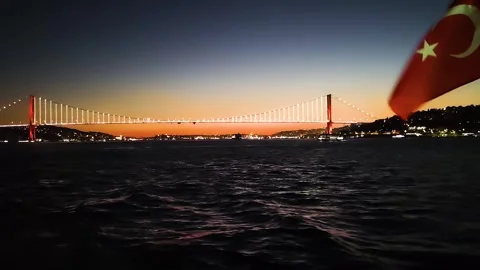 Sunset Over Bosphorus Bridge with Waving Turkish Flag in Istanbul - 4K Footage Stock Footage 327043411