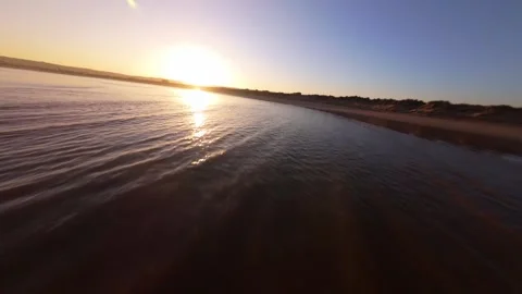 Sunset over calm beach with gentle waves and warm reflections Stock Footage 344582857