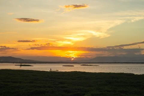 Sunset Over Calm Lake with Distant Mountains Fotos Stock