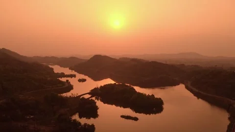 Sunset Over Calm Lake Surrounded By Silhouetted Mountains And Lush Greenery Stock Footage 342030112