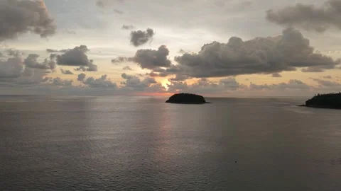 Sunset over calm ocean with island silhouette and dramatic cloud formations Stock Footage 337418126