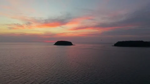 Sunset over calm ocean with islands and colorful sky reflections Stock Footage 336913340