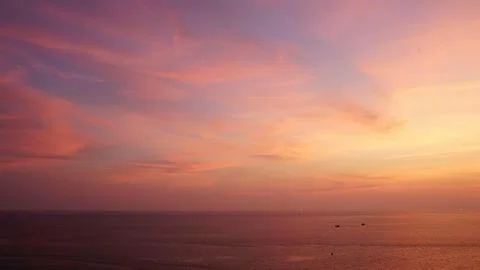 Sunset over calm ocean with pink and orange sky Stock Photos