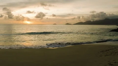 Sunset over calm ocean with reflections on the sandy shore. Seychelles, Mahe. Stock Footage 312583782