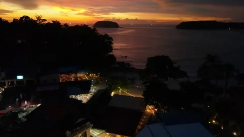Sunset over calm ocean with silhouettes of trees and distant islands visible Stock Footage 342332769