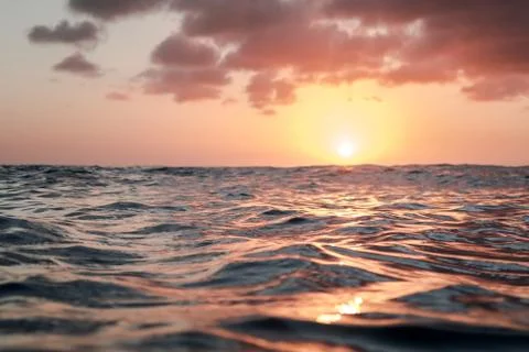 Sunset over calm ocean smooth water  Stock Photos