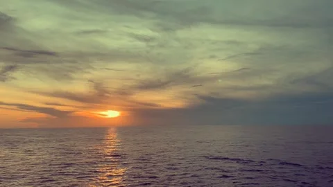Sunset Over Calm Ocean with Vibrant Clouds and Peaceful Horizon Stock Footage 338281679