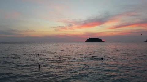 Sunset over calm ocean waters with distant island silhouette and colorful sky Vídeos de archivo 340407099