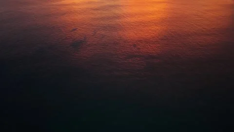 Sunset over calm ocean waters with distant island and colorful sky reflections Stock-Footage 342313110