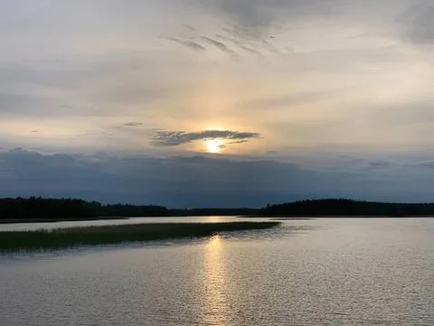 Sunset over calm river with cloudy sky and reflections Stock Photos