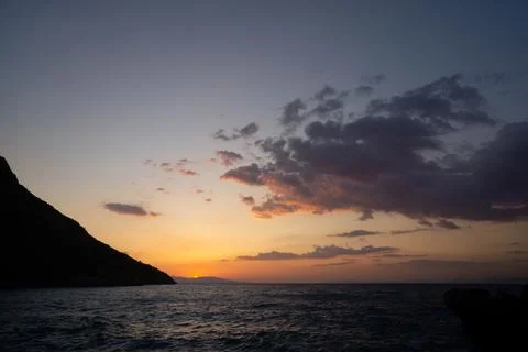 Sunset Over Calm Sea with Dramatic Clouds Stock-Fotos