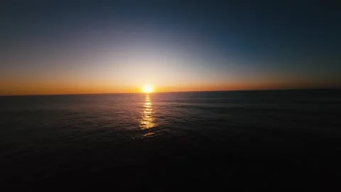 Sunset over calm sea, light fades slowly across horizon Stock Footage 339789126