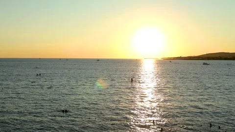 Sunset over calm sea waters with boats visible on the horizon, Stock Footage 344810640