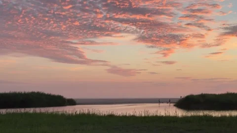 Sunset Over Calm Water and Grassy Shore Stock Footage 285186077