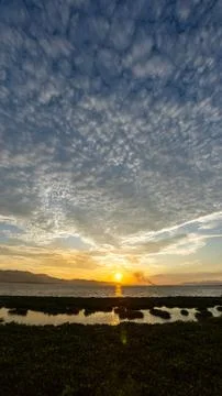 Sunset Over Calm Water with Clouds 스톡 사진