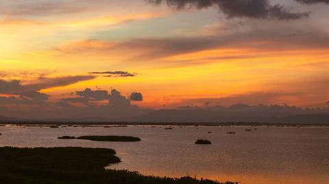 Sunset Over Calm Water With Distant Mountains 스톡 사진