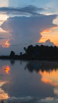 Sunset Over Calm Water with Dramatic Clouds Fotos de archivo