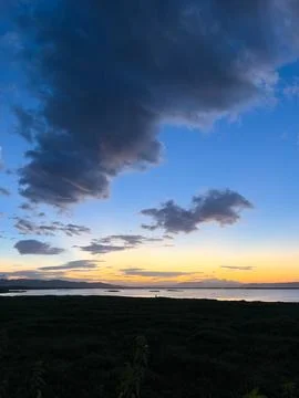 Sunset Over Calm Water with Dramatic Clouds Stock Photos