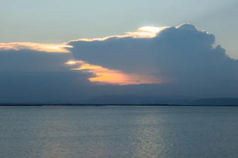 Sunset Over Calm Water with Dramatic Clouds Foto stock