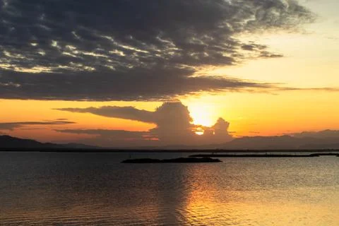 Sunset Over Calm Water with Dramatic Clouds 库存照片