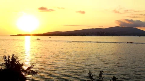 Sunset over calm waters with silhouetted figures Stock-Footage 344813422