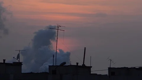Sunset over city and behind industrial smoke, pollution. Video stock 96209511