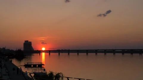 Sunset over the city and the bridge people walking along the promenade. Stock-Footage 276648286