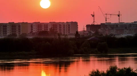 Sunset over a city being construction built. River or lake. 4k timelapse Stock Footage 52246033