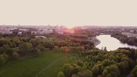 Sunset over the city. The drone flies over the city park near the river Stock Footage 194586970