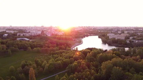 Sunset over the city. The drone flies over the city park near the river Stock Footage 194587094