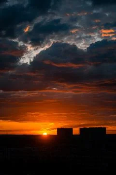 Sunset over city skyline with dramatic clouds Stock Photos