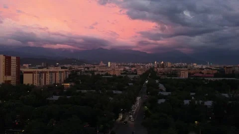 Sunset over city skyline with mountains and colorful clouds in background Stock Footage 339124265