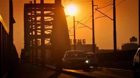 Sunset over the city (time lapse). Silhouetted people walking over bridge. Stock Footage 22483280