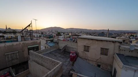 Sunset Over Cityscape with Mountain Backdrop Stock Photos