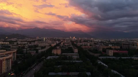 Sunset over cityscape with mountains and clouds in the background Stock Footage 339124039
