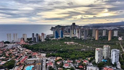 Sunset Over Cityscape Structures, Panoramic View Featuring Skyscrapers And Lush Stock Photos