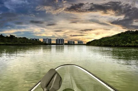 Sunset over clear see-through kayak forges its way through the waters of Deln Stock Photos