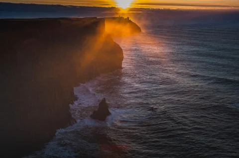 Sunset over the Cliffs of Moher as mist rises from the Atlantic Ocean Stock Photos
