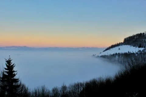 Sunset over the clouds and mountains Stock Photos