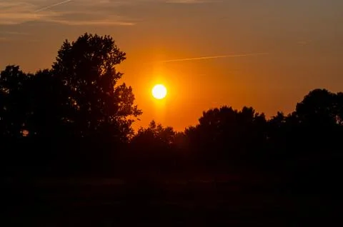 Sunset over the  clouds in the nature between the fields Stock Photos