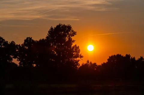 Sunset over the  clouds in the nature between the fields Stock Photos
