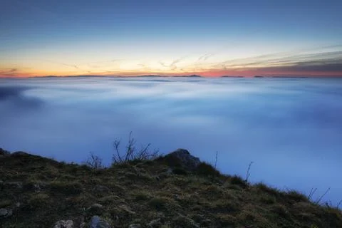 Sunset over clouds Stock Photos