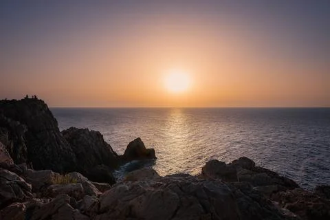Sunset over the coast, rock formations, big ball sunshine Stock Photos