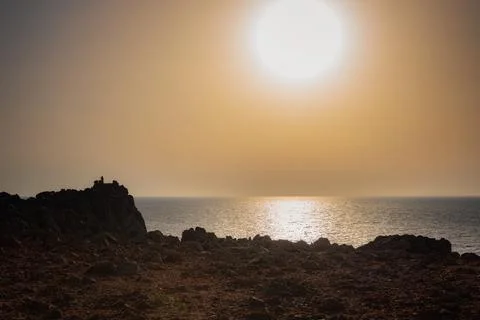Sunset over the coast, rock formations, big ball sunshine Stock Photos